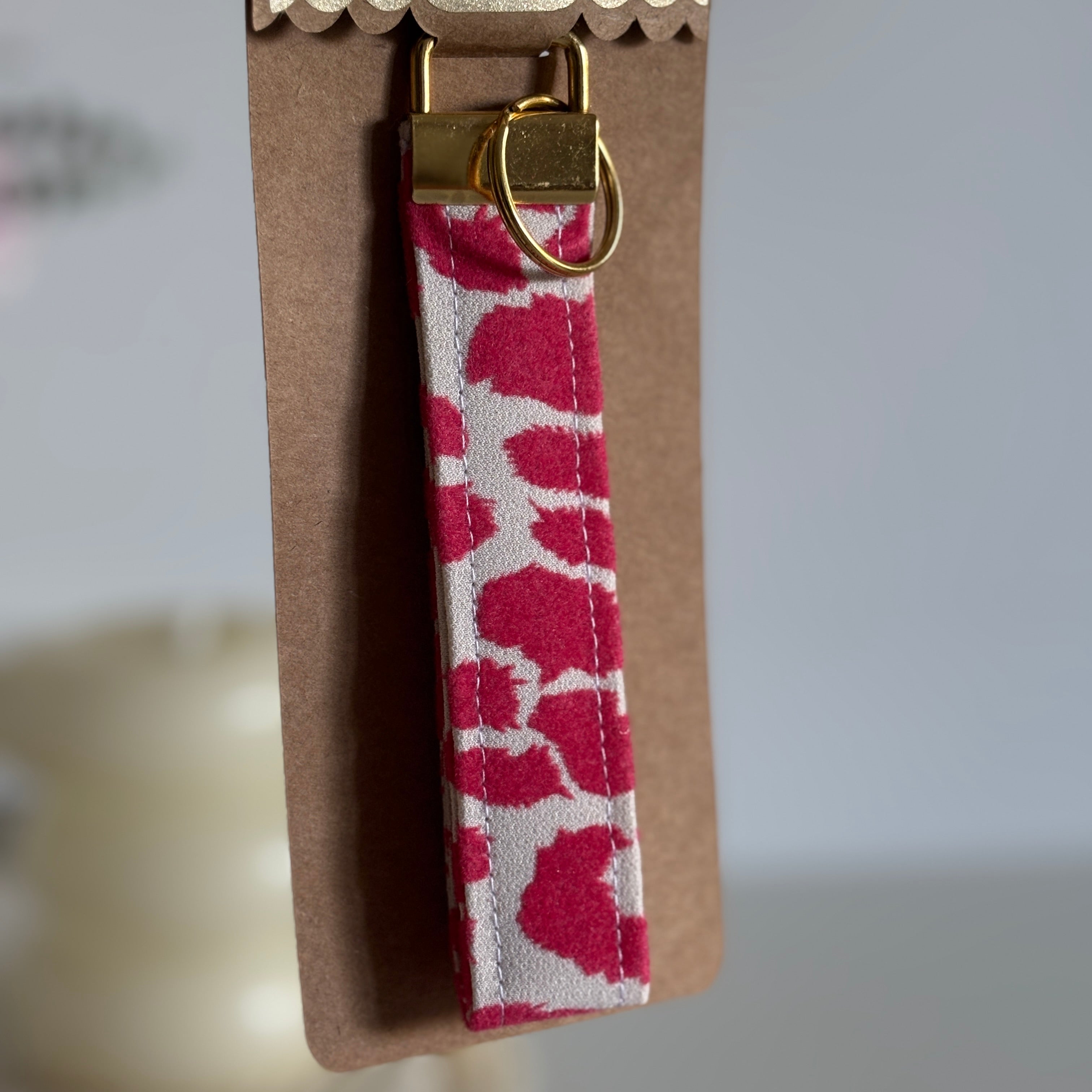 Porte Clé Bellatrix – Motif léopard rose et blanc avec finitions dorées
