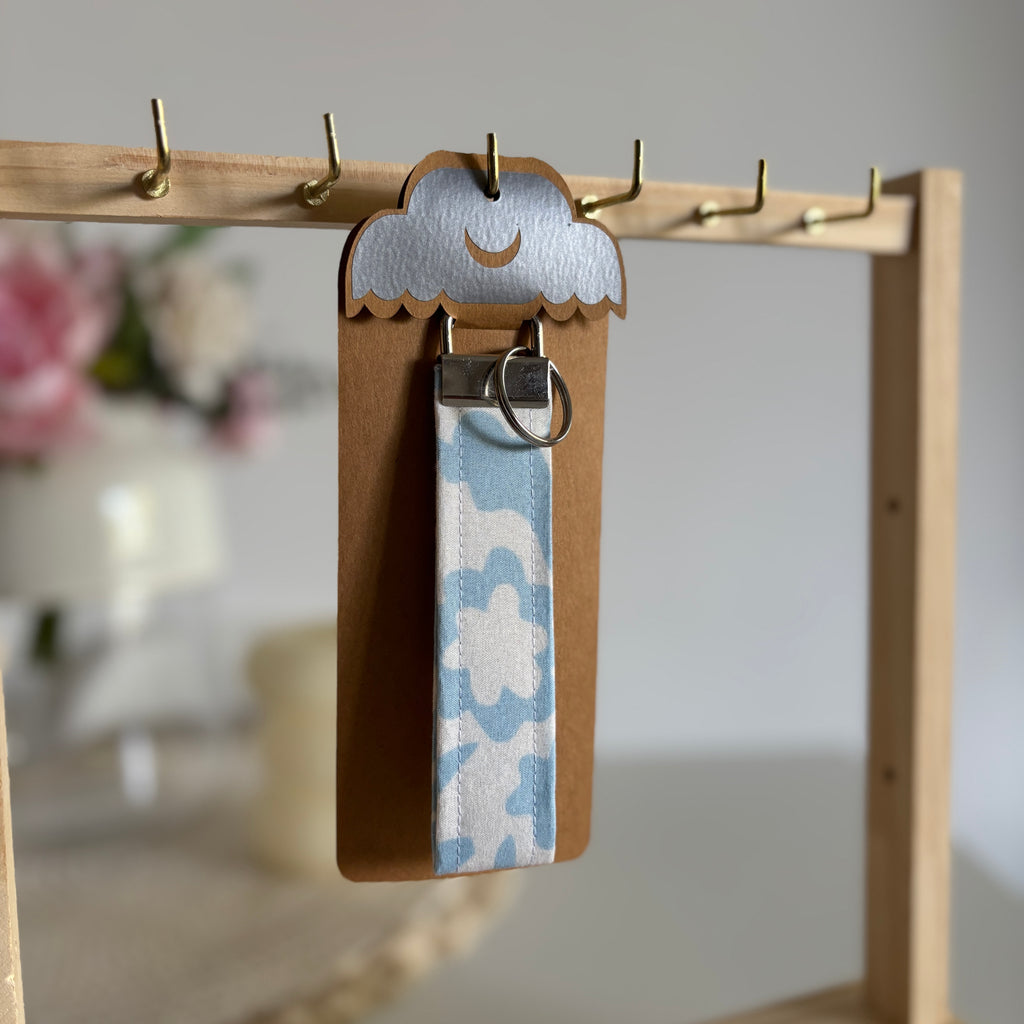 Porte Clé Lyra – Motif fleurs bleu ciel avec finitions argentées