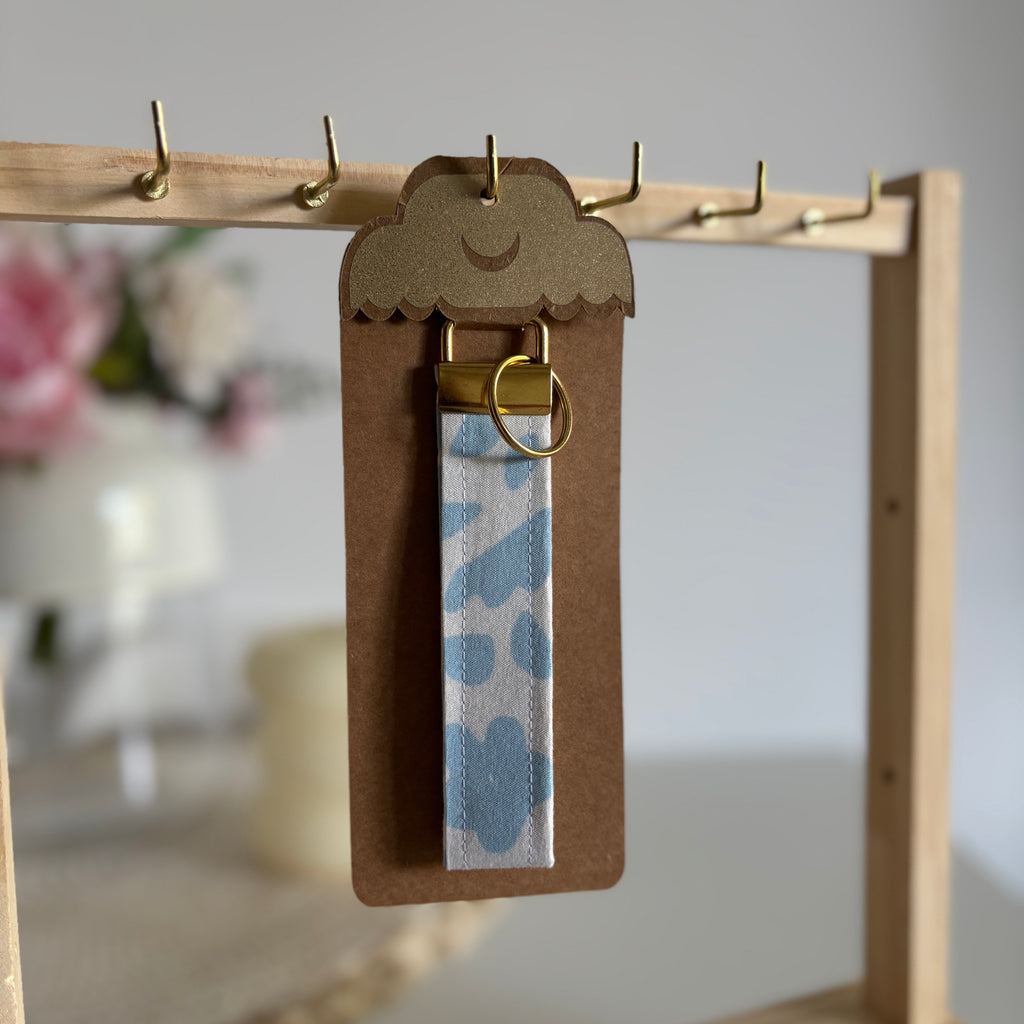 Porte Clé Lyra – Motif fleurs bleu ciel avec finitions dorées