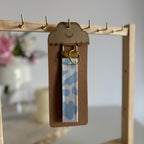 Porte Clé Léna – Motif fleurs bleu ciel avec finitions dorées