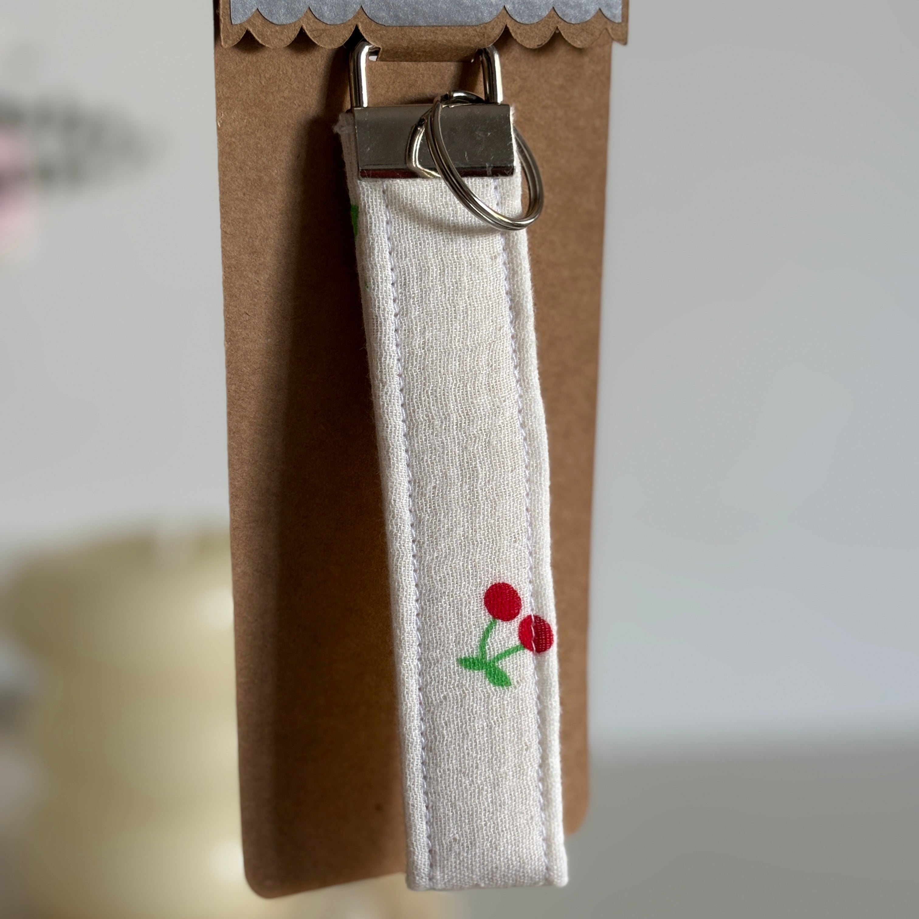 Porte Clé Aurélie – Motif cerise en gaze blanc avec finitions argentées