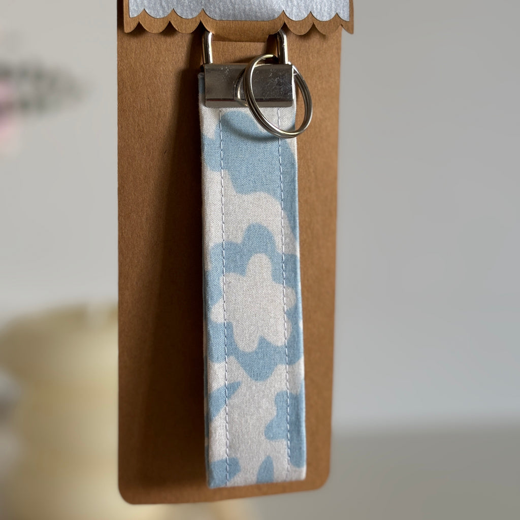Porte Clé Lyra – Motif fleurs bleu ciel avec finitions argentées