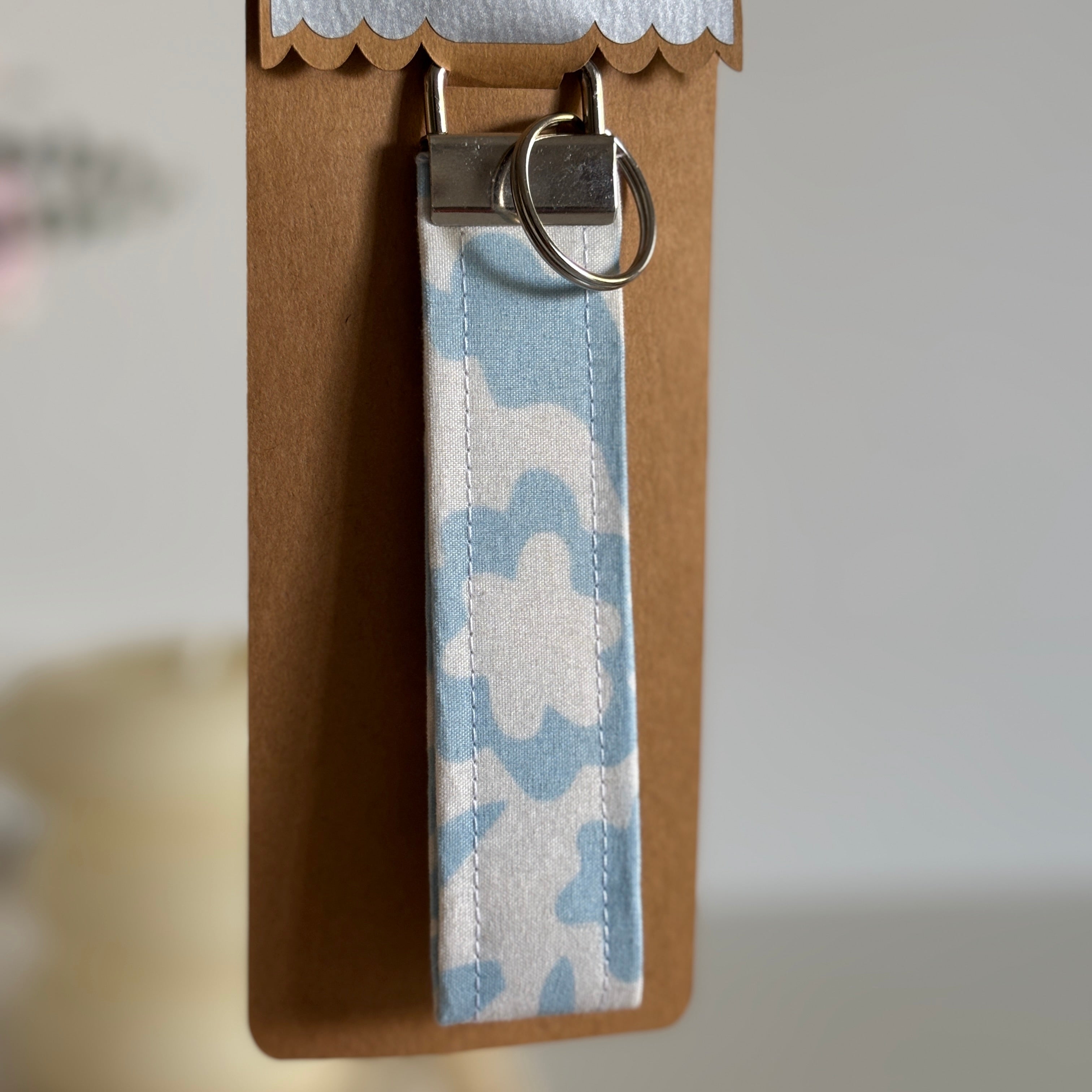 Porte Clé Lyra – Motif fleurs bleu ciel avec finitions argentées