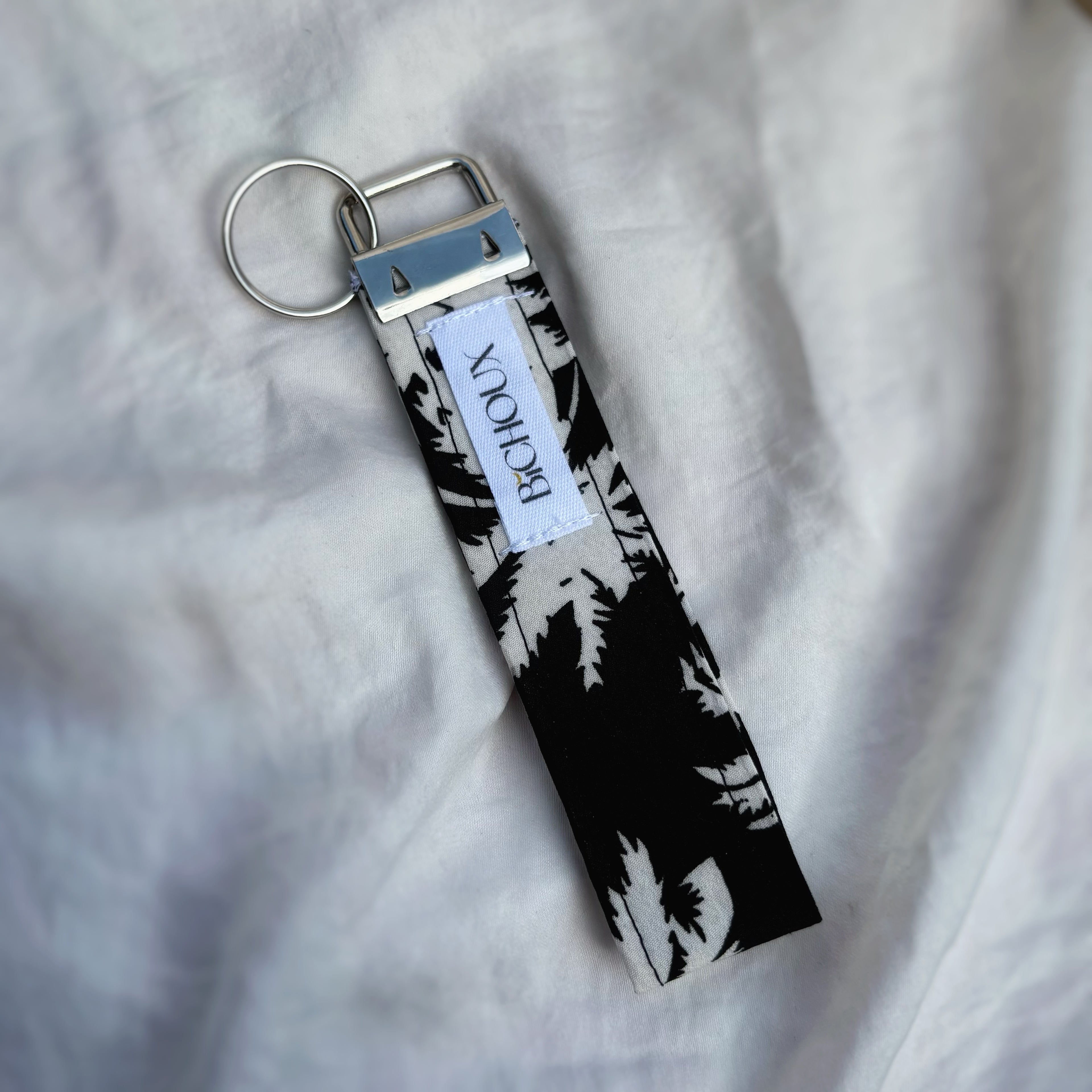 Porte Clé Altaïr – Motif palmier noir & blanc avec finitions argentées