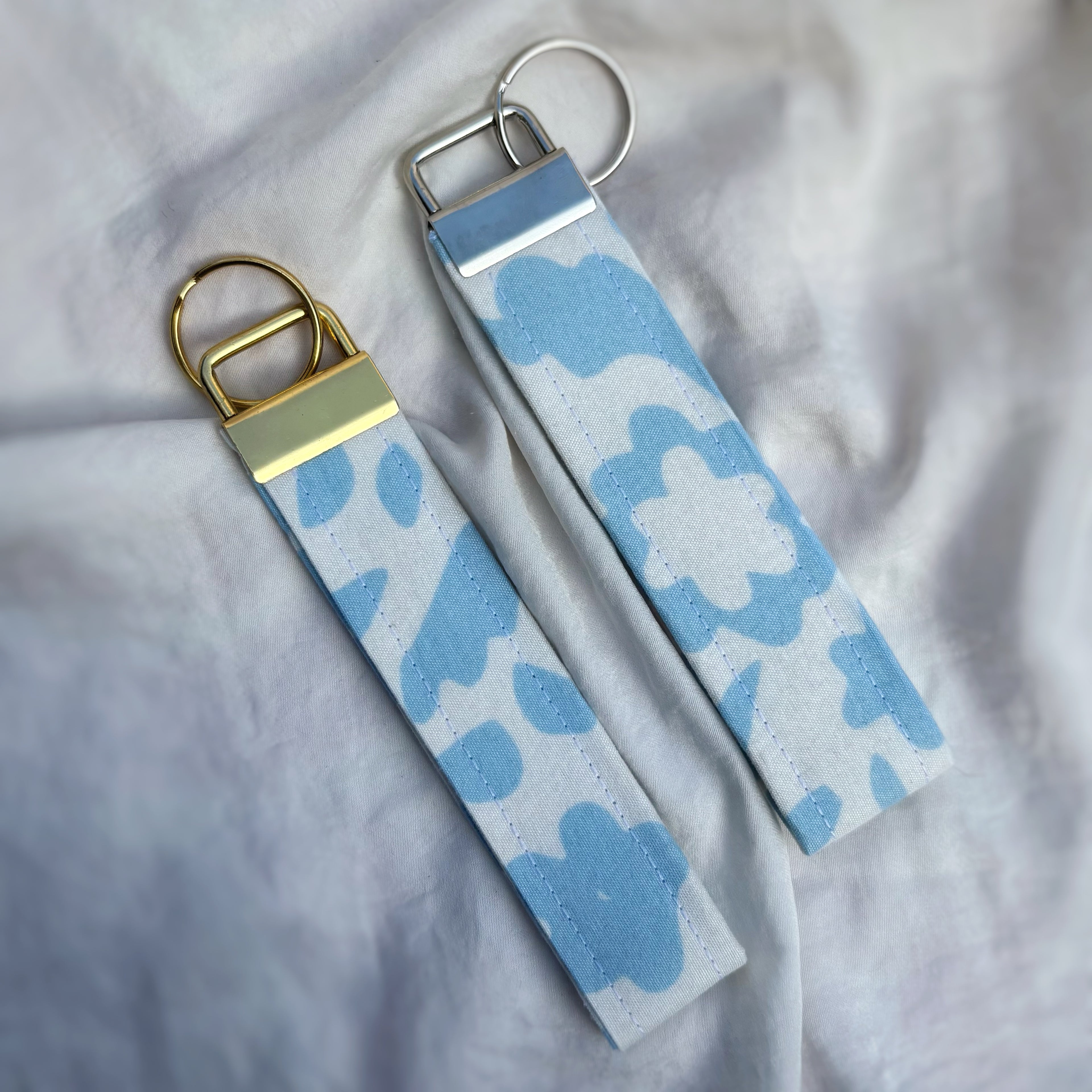Porte Clé Lyra – Motif fleurs bleu ciel avec finitions dorées
