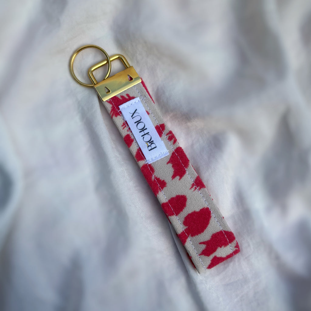 Porte Clé Bellatrix – Motif léopard rose et blanc avec finitions dorées