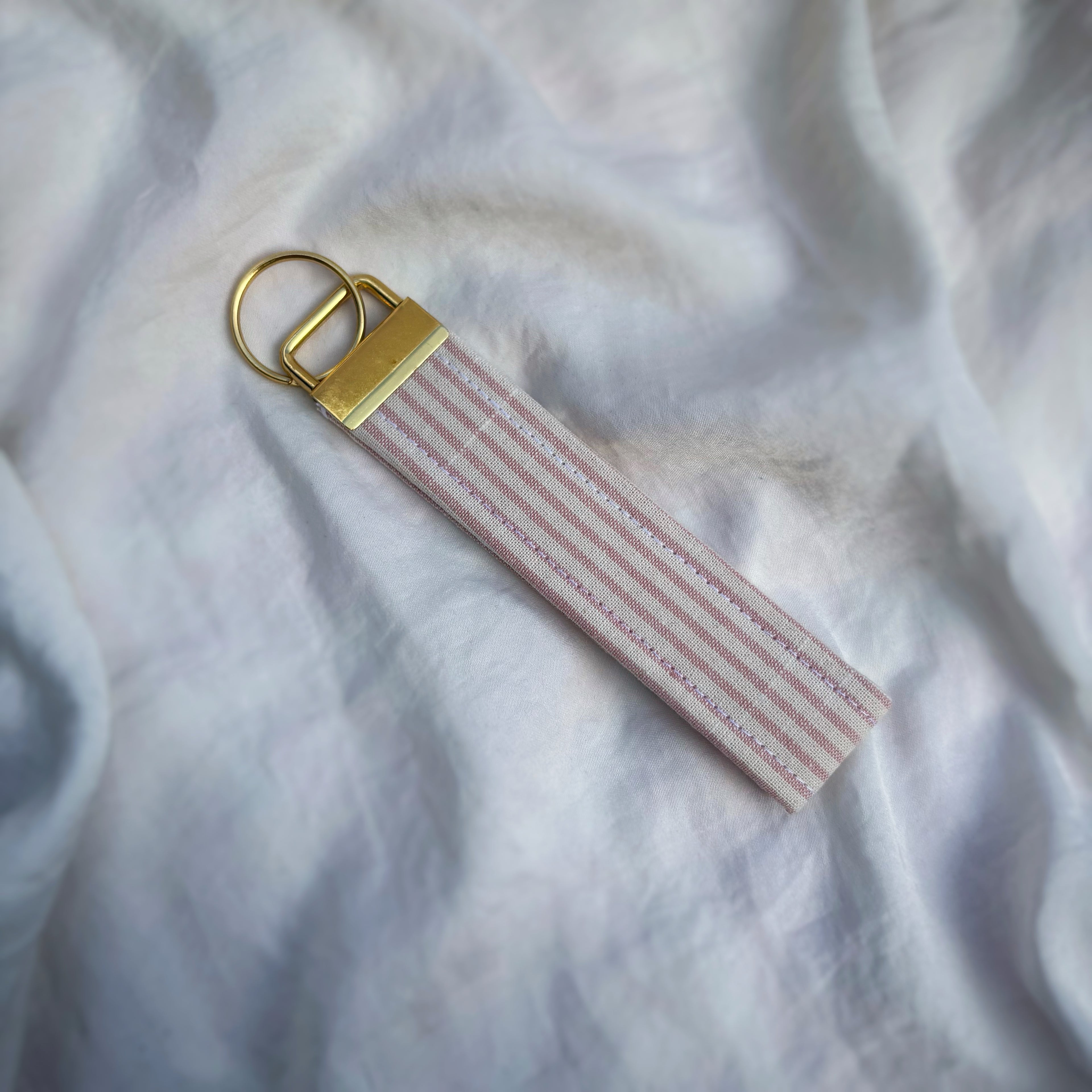 Porte Clé Arcturus - Motif rayé rose et blanc avec finitions dorées