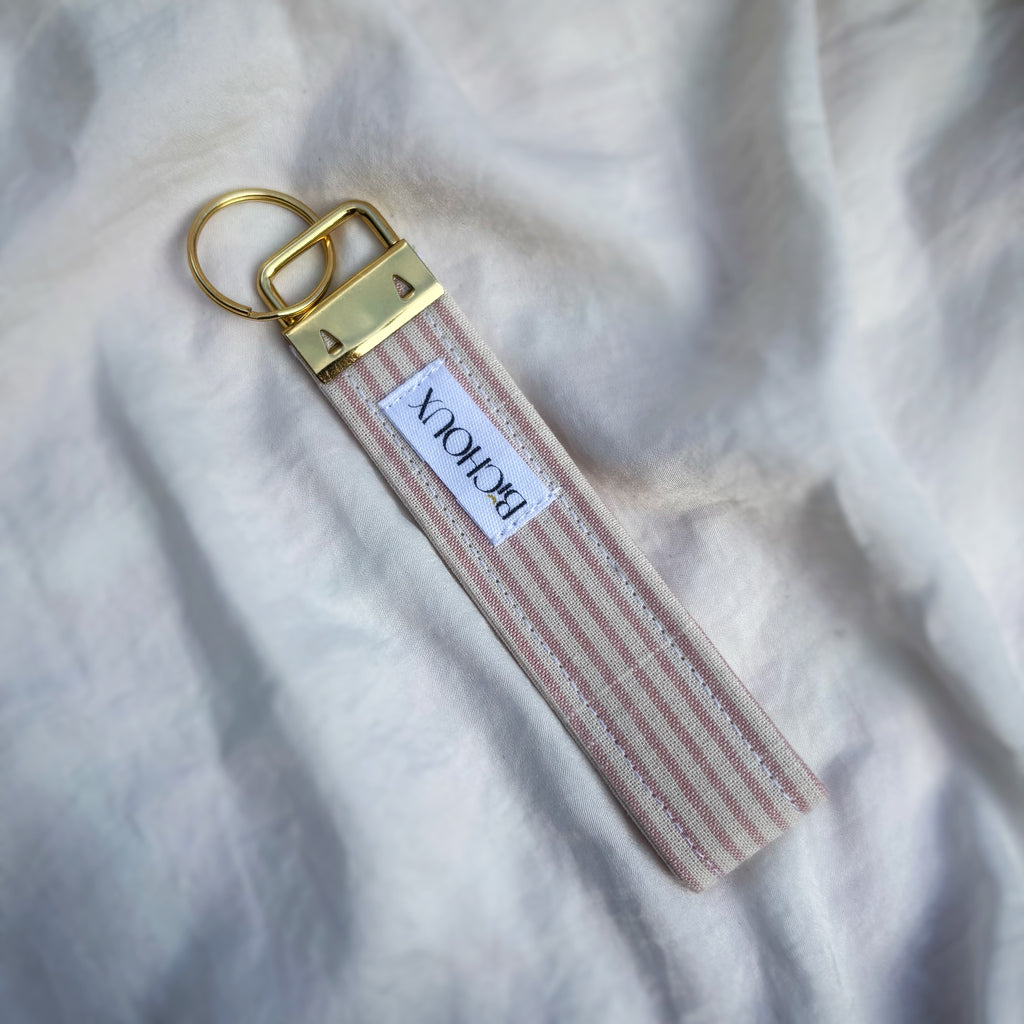 Porte Clé Arcturus - Motif rayé rose et blanc avec finitions dorées