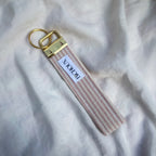 Porte Clé Arcturus - Motif rayé rose et blanc avec finitions dorées