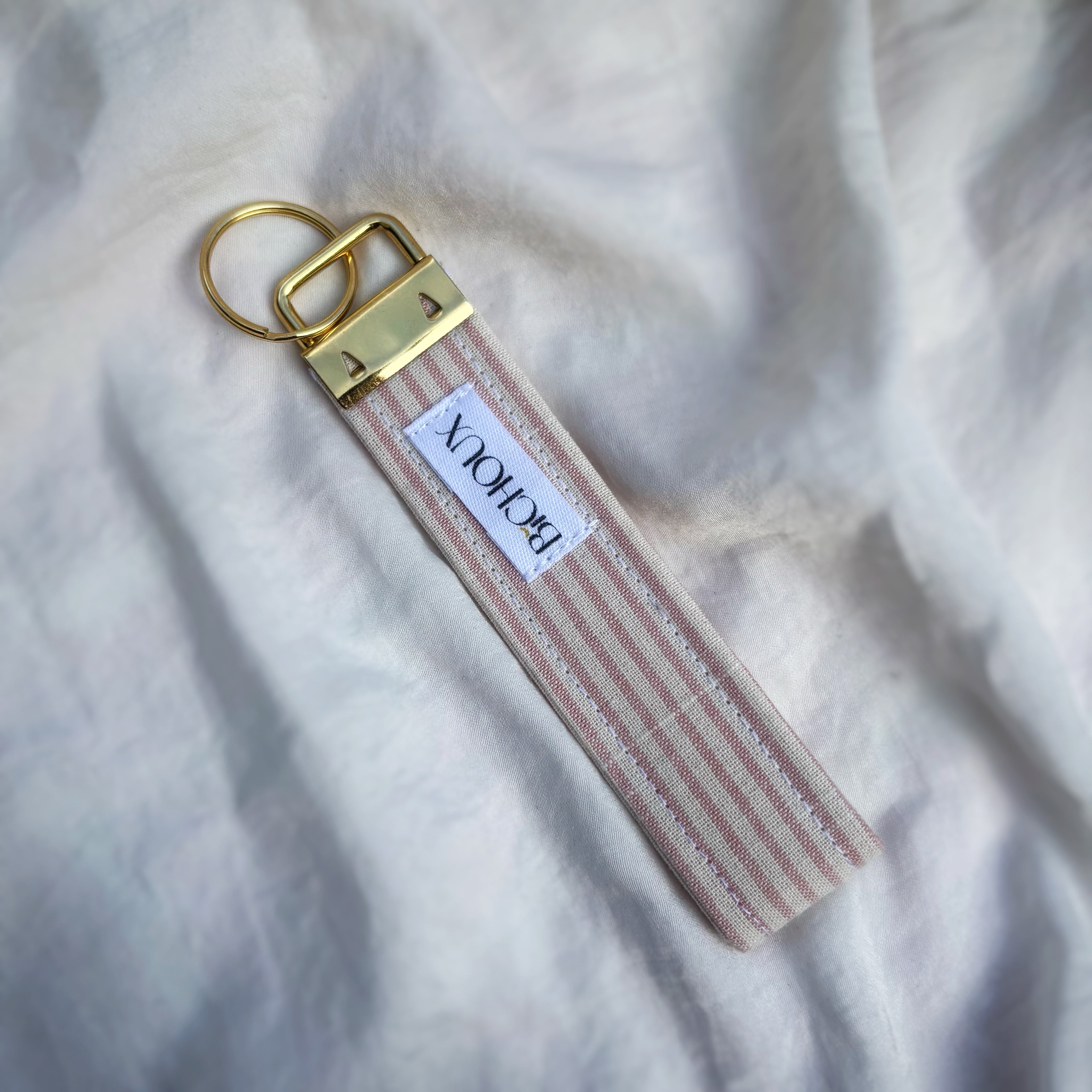 Porte Clé Arcturus - Motif rayé rose et blanc avec finitions dorées