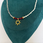 Collier Solmira – Perles blanches, grises et pendentif soleil