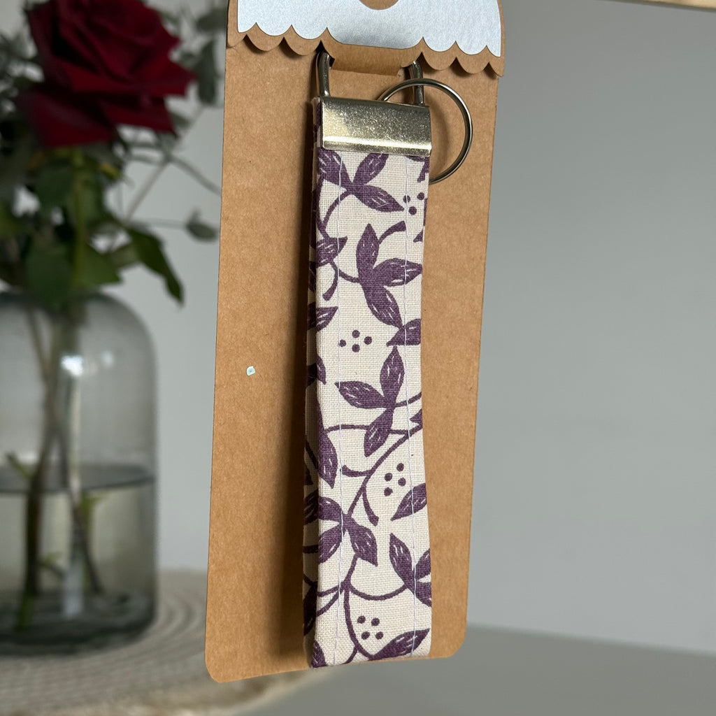 Porte-clés Lysandra - Fleurs prune sur fond blanc avec finitions argentées